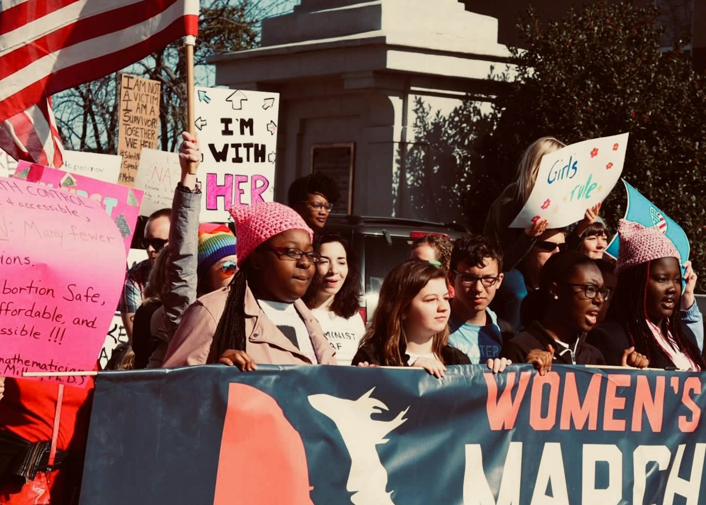 Protesters carry a large banner during an outdoor march.